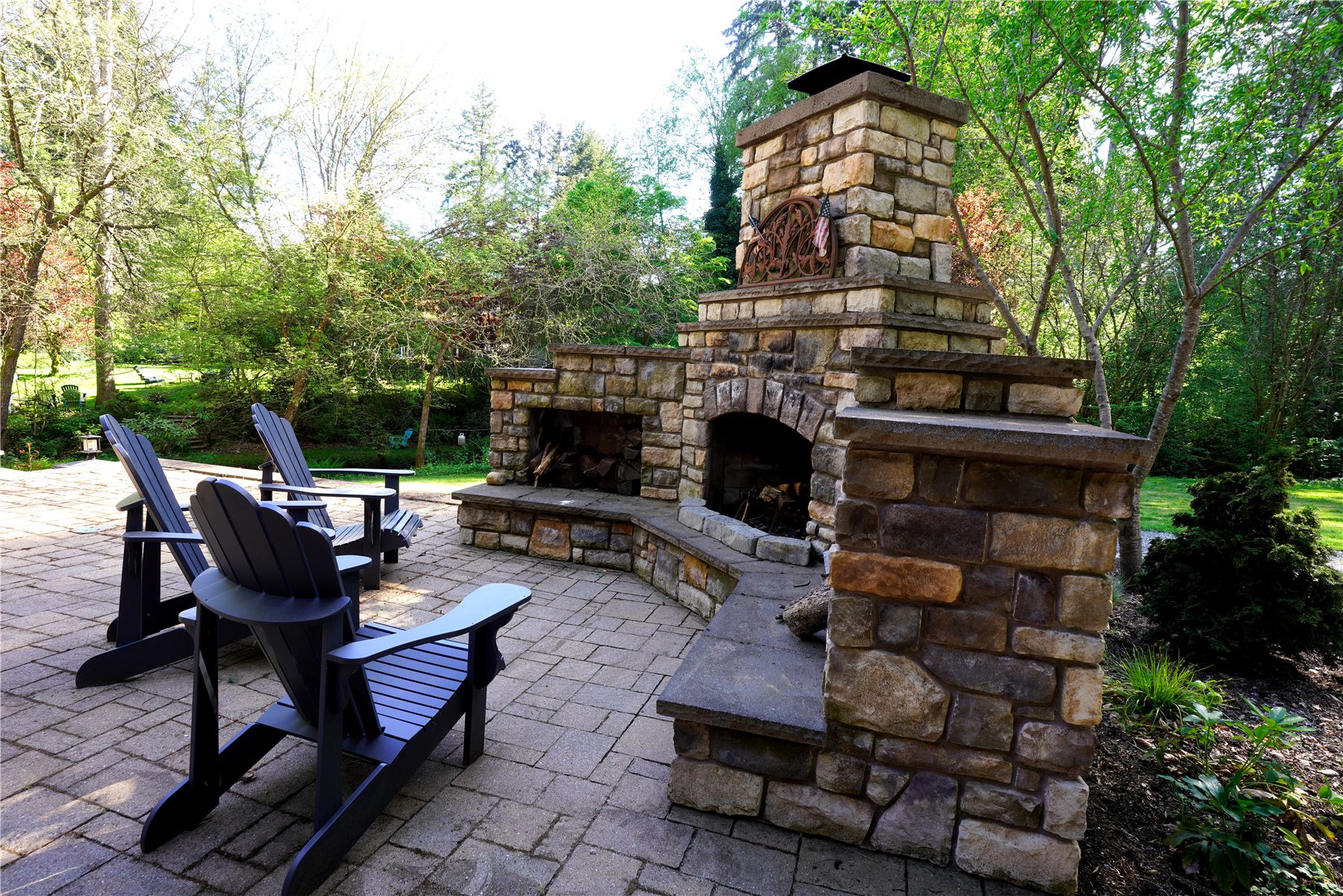 Stone outdoor fireplace with Adirondack chairs