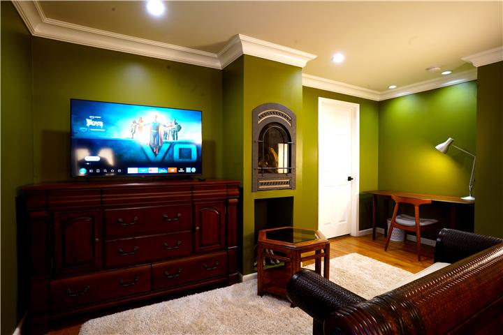 Primary suite sitting area with TV and fireplace