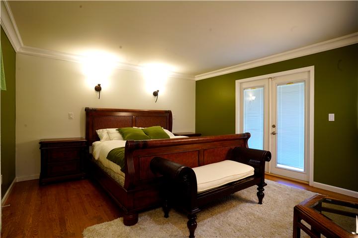 Primary bedroom with king sleigh bed and French doors