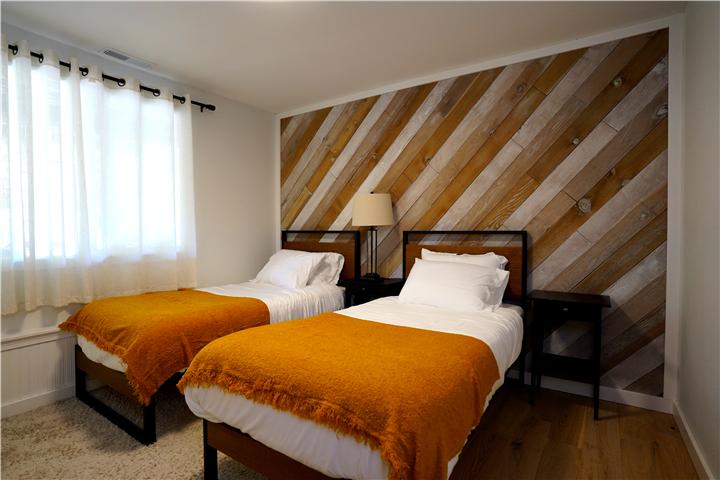 Bedroom with two twin beds and a reclaimed-wood accent wall